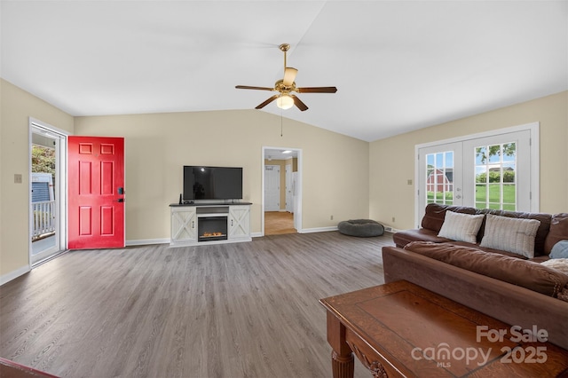5445 Creekwood Dr, Salisbury, NC 28147 - living room featuring vaulted ceiling, wood finished floors, ceiling fan, french doors, and a warm lit fireplace