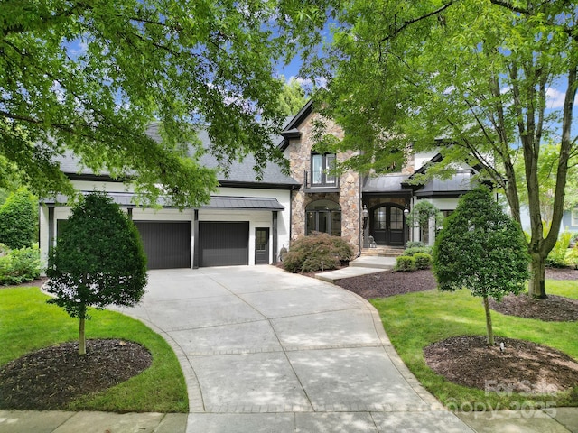 8016 Pemswood St, Charlotte, NC 28277 - view of front of property featuring stone siding, concrete driveway, a front lawn, and an attached garage