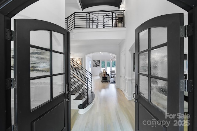 8016 Pemswood St, Charlotte, NC 28277 - entrance foyer with arched walkways, wood finished floors, and a high ceiling