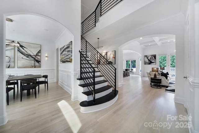8016 Pemswood St, Charlotte, NC 28277 - stairs with arched walkways, wood finished floors, a decorative wall, a wainscoted wall, and beamed ceiling