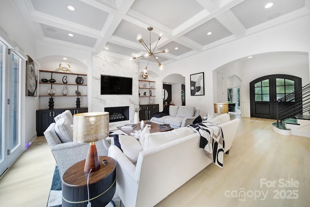 8016 Pemswood St, Charlotte, NC 28277 - living area with arched walkways, light wood-type flooring, coffered ceiling, a high end fireplace, and beamed ceiling