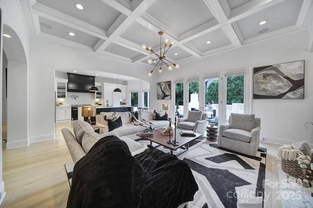8016 Pemswood St, Charlotte, NC 28277 - living area featuring coffered ceiling, light wood finished floors, arched walkways, a chandelier, and beamed ceiling