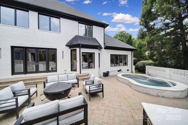 8016 Pemswood St, Charlotte, NC 28277 - back of property featuring brick siding, an outdoor living space with a fire pit, an outdoor hot tub, and a patio area