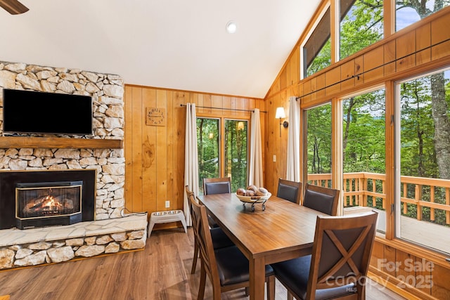 285 Fairway Loop Unit 7, Burnsville, NC 28714 - dining space featuring vaulted ceiling, wood finished floors, healthy amount of natural light, wood walls, and a fireplace