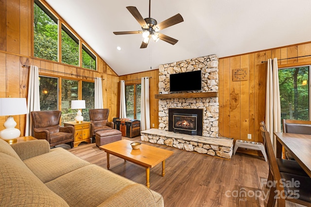 285 Fairway Loop Unit 7, Burnsville, NC 28714 - living room featuring wooden walls, a ceiling fan, high vaulted ceiling, wood finished floors, and a fireplace