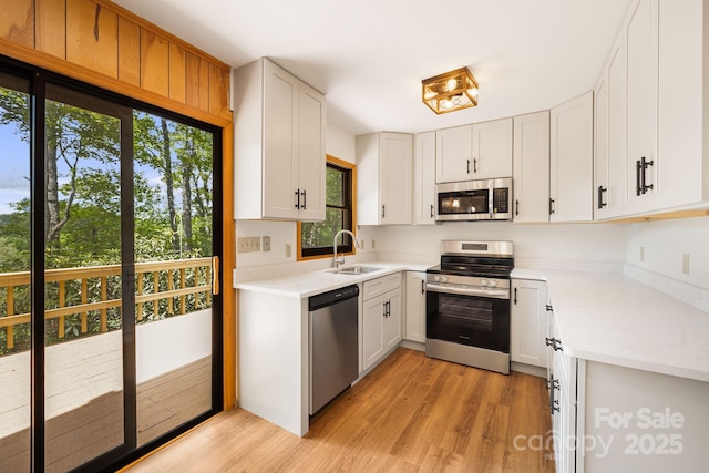 285 Fairway Loop Unit 7, Burnsville, NC 28714 - kitchen featuring stainless steel appliances, light wood finished floors, light countertops, and white cabinets