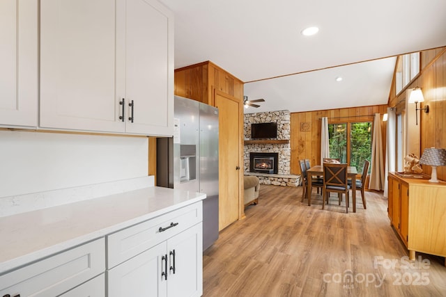 285 Fairway Loop Unit 7, Burnsville, NC 28714 - kitchen with stainless steel fridge with ice dispenser, a stone fireplace, ceiling fan, light countertops, and light wood-style floors