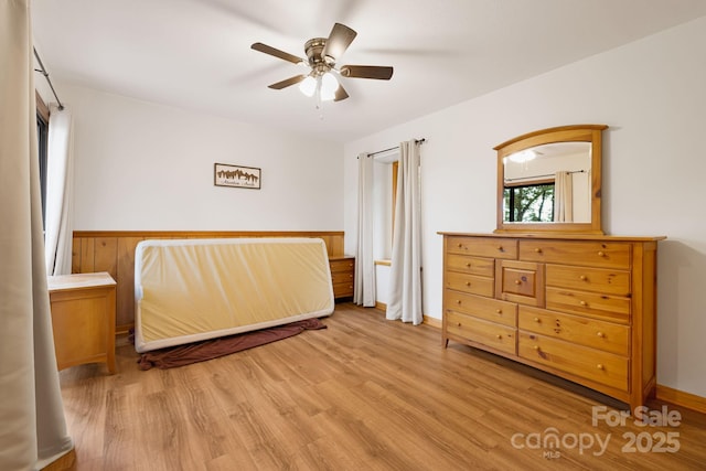 285 Fairway Loop Unit 7, Burnsville, NC 28714 - bedroom with wood finished floors, a wainscoted wall, and a ceiling fan
