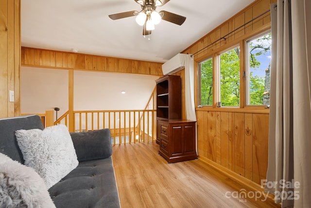 285 Fairway Loop Unit 7, Burnsville, NC 28714 - living area featuring ceiling fan, light wood finished floors, wood walls, and a wall mounted air conditioner