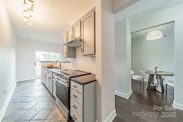 1315 E Blvd Unit 327, Charlotte, NC 28203 - kitchen with stainless steel range with electric stovetop, under cabinet range hood, decorative backsplash, dishwasher, and dark countertops