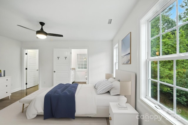 8782 Shepherd Ct, Hildebran, NC 28612 - bedroom featuring multiple windows, wood finished floors, ensuite bath, and a ceiling fan