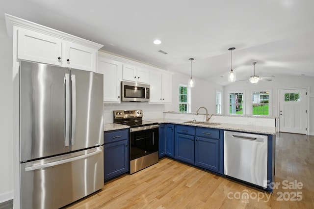 8782 Shepherd Ct, Hildebran, NC 28612 - kitchen featuring appliances with stainless steel finishes, blue cabinetry, a peninsula, white cabinets, and lofted ceiling
