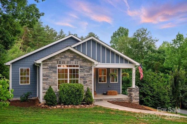 8782 Shepherd Ct, Hildebran, NC 28612 - view of front facade featuring stone siding, covered porch, and a front yard