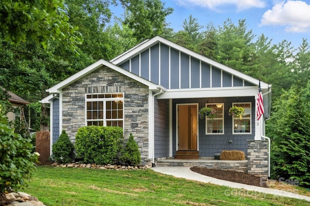 8782 Shepherd Ct, Hildebran, NC 28612 - view of front of house featuring stone siding, a front lawn, board and batten siding, and covered porch