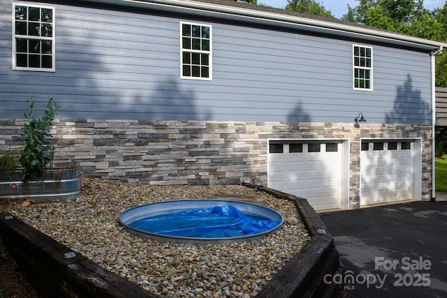 8782 Shepherd Ct, Hildebran, NC 28612 - view of home's exterior featuring stone siding, a garage, and asphalt driveway