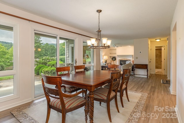 103 Golfside Dr, Flat Rock, NC 28731 - dining room featuring a chandelier, light wood finished floors, and a fireplace