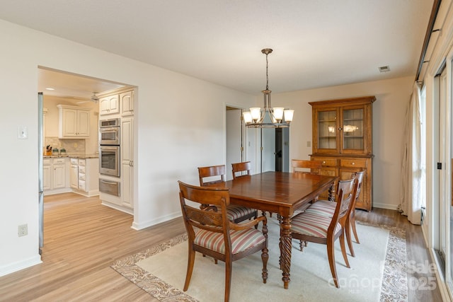 103 Golfside Dr, Flat Rock, NC 28731 - dining area featuring a chandelier, light wood-style flooring, and healthy amount of natural light