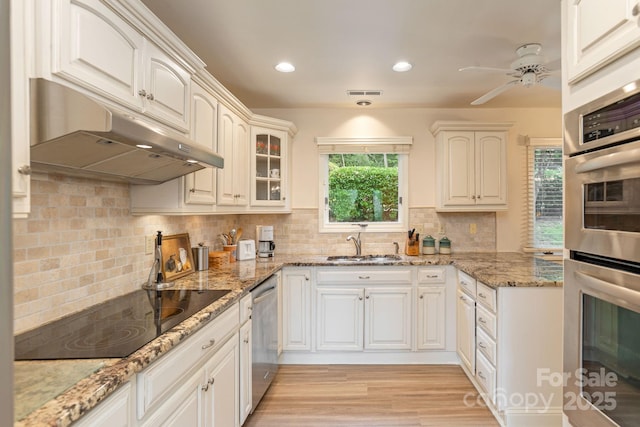103 Golfside Dr, Flat Rock, NC 28731 - kitchen with under cabinet range hood, appliances with stainless steel finishes, tasteful backsplash, glass insert cabinets, and recessed lighting
