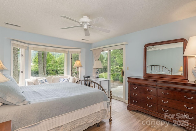 103 Golfside Dr, Flat Rock, NC 28731 - bedroom featuring access to exterior, light wood-style flooring, ceiling fan, and a textured ceiling