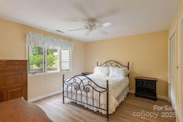103 Golfside Dr, Flat Rock, NC 28731 - bedroom featuring wood finished floors, a closet, a textured ceiling, and a ceiling fan