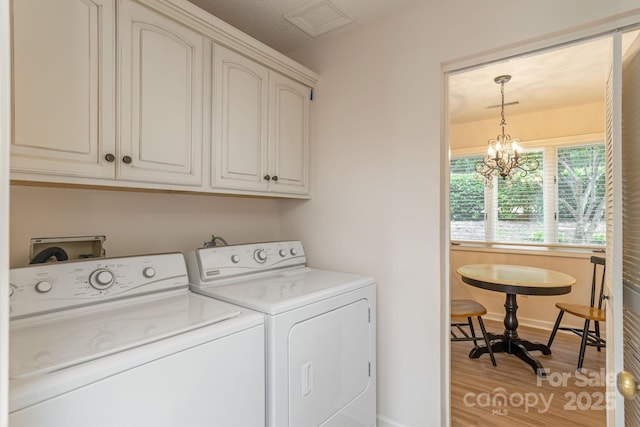 103 Golfside Dr, Flat Rock, NC 28731 - washroom with cabinet space, washing machine and dryer, light wood finished floors, and a chandelier