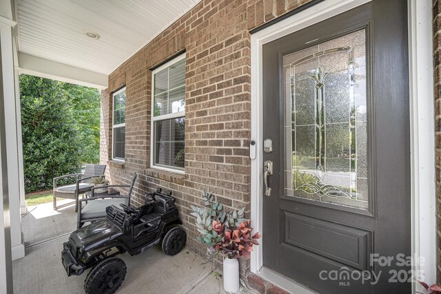 15636 Oleander Dr, Charlotte, NC 28278 - doorway to property featuring a porch and brick siding