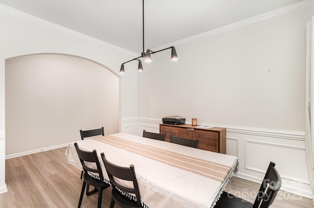 15636 Oleander Dr, Charlotte, NC 28278 - dining space with crown molding, light wood-style floors, a wainscoted wall, arched walkways, and a decorative wall
