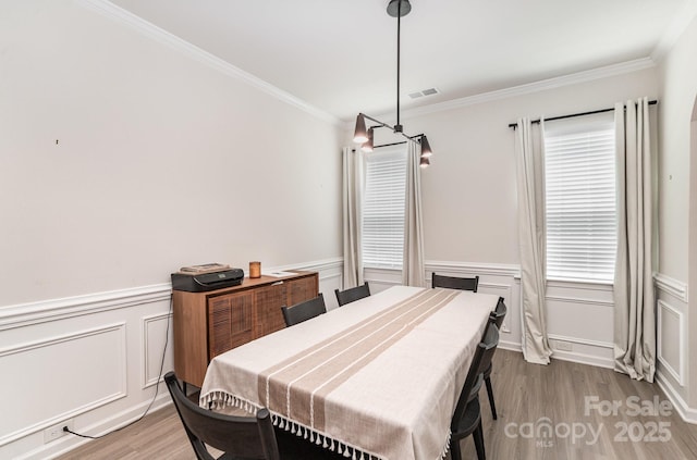 15636 Oleander Dr, Charlotte, NC 28278 - dining room featuring wood finished floors, ornamental molding, wainscoting, and a decorative wall