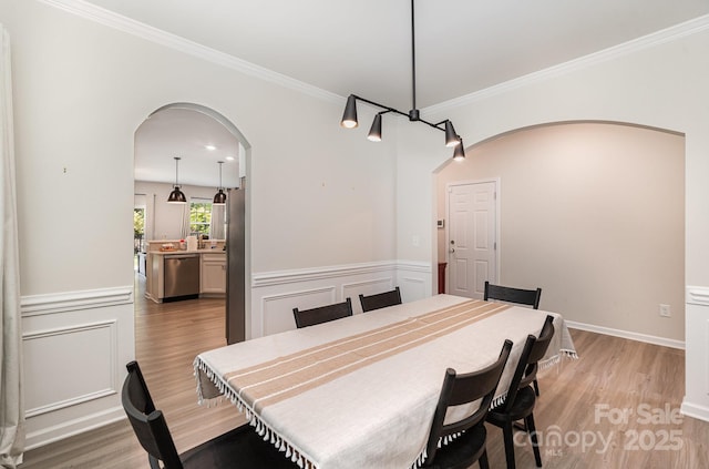 15636 Oleander Dr, Charlotte, NC 28278 - dining area with arched walkways, light wood-style floors, wainscoting, and ornamental molding