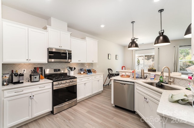 15636 Oleander Dr, Charlotte, NC 28278 - kitchen with stainless steel appliances, decorative backsplash, white cabinets, light wood-style floors, and recessed lighting