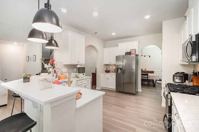 15636 Oleander Dr, Charlotte, NC 28278 - kitchen featuring stainless steel appliances, arched walkways, a peninsula, backsplash, and recessed lighting