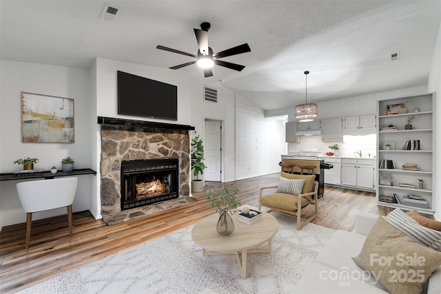 45B Mountain Vw, Villas, Franklin, NC 28734 - living room featuring light wood-style floors, lofted ceiling, a ceiling fan, and a fireplace
