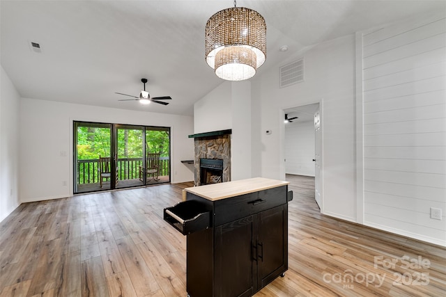 45B Mountain Vw, Villas, Franklin, NC 28734 - kitchen with a ceiling fan, open floor plan, light wood-style floors, a stone fireplace, and a chandelier