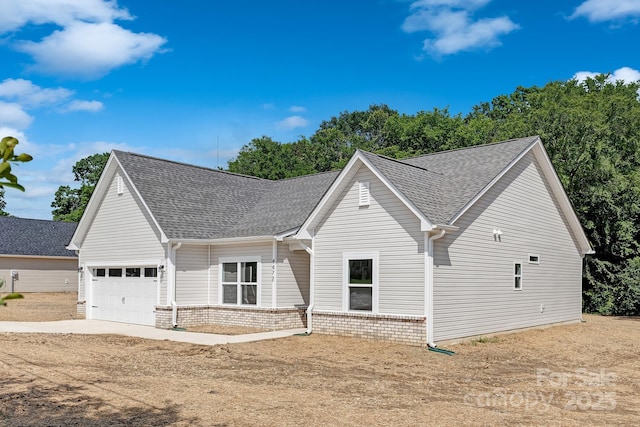 4472 Pebblebrook Cir SW, Concord, NC 28027 - view of front of house with a garage, brick siding, a shingled roof, and concrete driveway