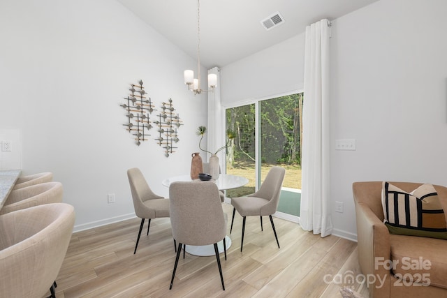 4472 Pebblebrook Cir SW, Concord, NC 28027 - dining space with light wood-type flooring, a chandelier, and vaulted ceiling