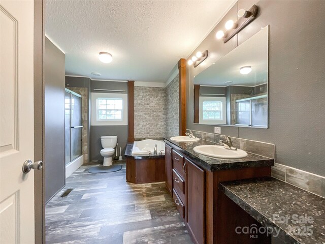 5321 State Line Rd, Marshville, NC 28103 - bathroom featuring wood finished floors, an enclosed shower, double vanity, a textured ceiling, and a tub
