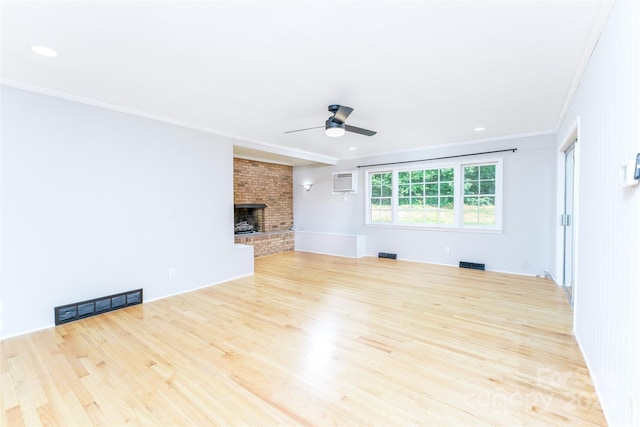 1728 Colony Rd, Salisbury, NC 28144 - unfurnished living room with ornamental molding, a ceiling fan, wood finished floors, a wall mounted AC, and a brick fireplace