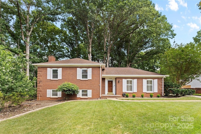 1024 Regency Dr, Charlotte, NC 28211 - split level home featuring a chimney, a front yard, brick siding, and roof with shingles
