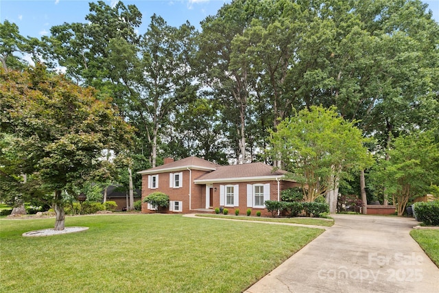 1024 Regency Dr, Charlotte, NC 28211 - split level home with brick siding, a front yard, a chimney, and concrete driveway