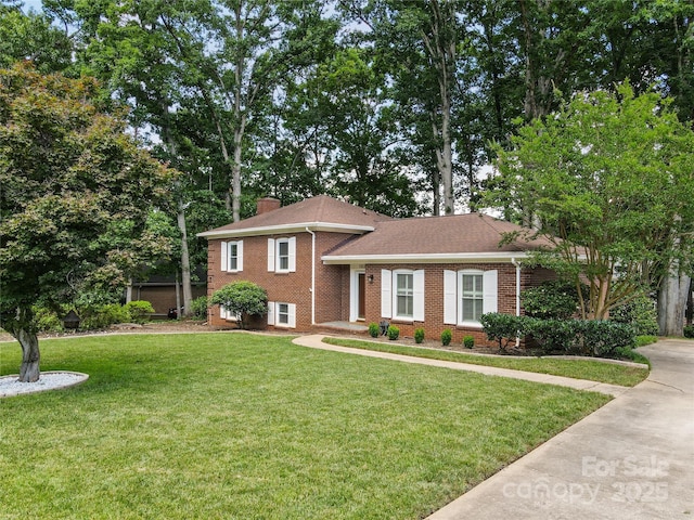 1024 Regency Dr, Charlotte, NC 28211 - tri-level home featuring brick siding, a front yard, and a chimney