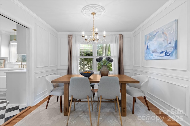 1024 Regency Dr, Charlotte, NC 28211 - dining area with a decorative wall, a chandelier, crown molding, and light wood finished floors