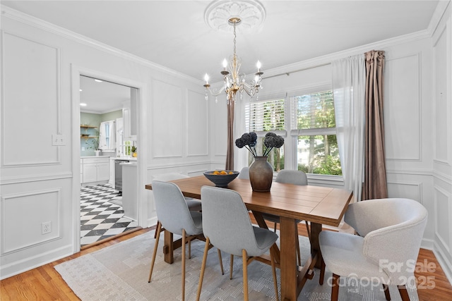 1024 Regency Dr, Charlotte, NC 28211 - dining area with a decorative wall, a chandelier, ornamental molding, and light wood-style floors