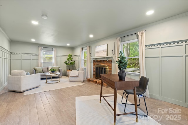 1024 Regency Dr, Charlotte, NC 28211 - living room with a decorative wall, crown molding, light wood finished floors, a brick fireplace, and recessed lighting