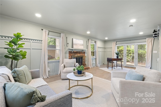 1024 Regency Dr, Charlotte, NC 28211 - living room with crown molding, light wood finished floors, a fireplace, recessed lighting, and a decorative wall