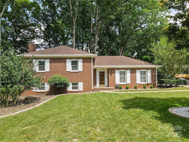 1024 Regency Dr, Charlotte, NC 28211 - split level home featuring a chimney, a front lawn, brick siding, and a shingled roof