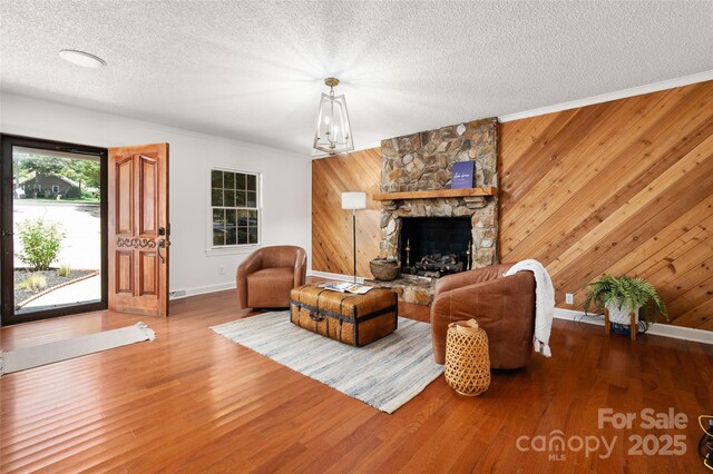 6259 River Cabin Ln, Charlotte, NC 28278 - living room featuring a textured ceiling, wood walls, a fireplace, and wood finished floors
