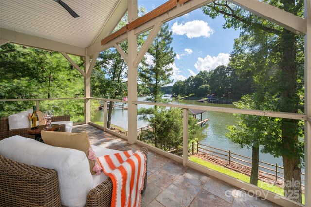 6259 River Cabin Ln, Charlotte, NC 28278 - sunroom featuring a water view, vaulted ceiling, a ceiling fan, and view of wooded area
