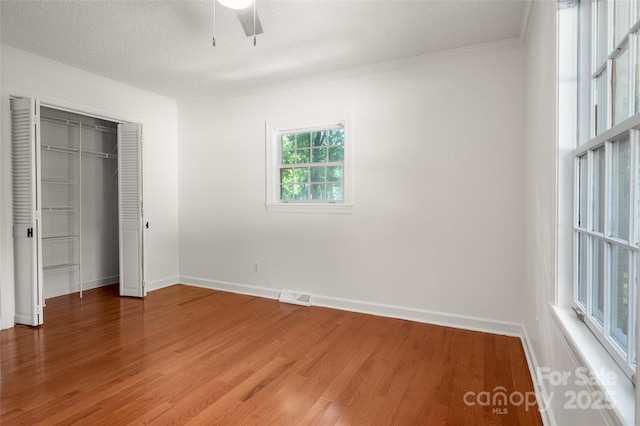 6259 River Cabin Ln, Charlotte, NC 28278 - unfurnished bedroom featuring light wood finished floors, a closet, ceiling fan, crown molding, and a textured ceiling