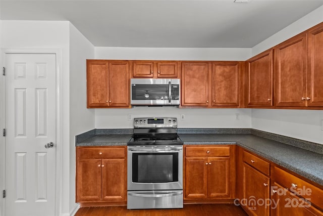516 Cool Creek Dr, Rock Hill, SC 29732 - kitchen featuring stainless steel appliances, dark countertops, dark wood-type flooring, and brown cabinetry