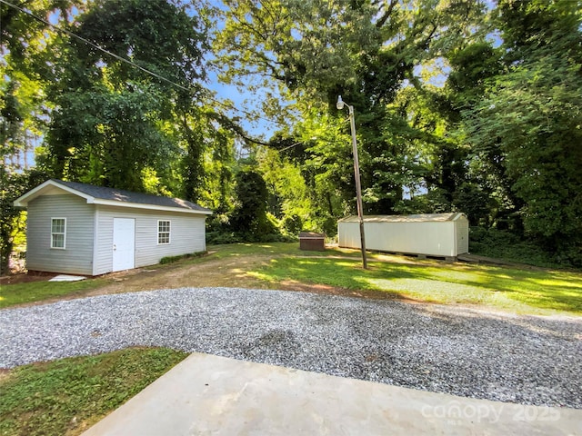 7812 Old Concord Rd, Salisbury, NC 28146 - view of grassy yard with a storage unit, view of wooded area, and a patio area